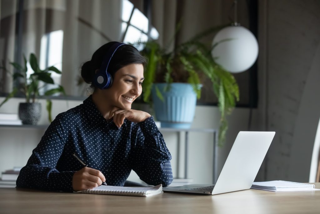 Happy,Young,Indian,Girl,With,Wireless,Headphones,Looking,At,Laptop